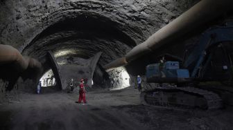 Pekerja dengan alat berat menyelesaikan pengerjaan proyek Kereta Cepat Jakarta-Bandung (KCJB) Tunnel 2 di Desa Bunder, Jatiluhur, Kabupaten Purwakarta, Jawa Barat, Kamis (27/1/2021). [Suara.com/Angga Budhiyanto]