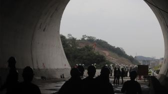 Siluet pekerja meninjau pengerjaan proyek Tunnel 6 Kereta Cepat Jakarta-Bandung (KCJB) di Kecamatan Cikalong Wetan, Kabupaten Bandung Barat, Jawa Barat, Kamis (27/1/2022). [Suara.com/Angga Budhiyanto]