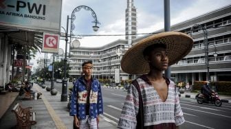 Sejumlah model memeragakan busana dari kain khas nusantara saat penampilan fesyen di ruang publik di Jalan Asia Afrika, Bandung, Jawa Barat, Jumat (28/1/2022). [ANTARA FOTO/Raisan Al Farisi]