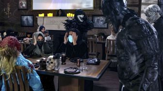 Aktor berkostum zombie memeriahkan suasana di restoran &quot;Shadows&quot; bertema horor di kota hiburan Boulevard, Riyadh, Arab Saudi, pada (19/1/2022). [FAYEZ NURELDINE / AFP]