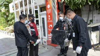 Petugas keamanan menyemprotkan cairan disinfektan pada paket barang di Kantor Pusat Kementerian Sosial (Kemensos), Jakarta, Jumat (28/1/2022). [ANTARA FOTO/M Risyal Hidayat]