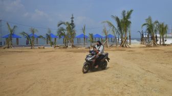 Warga melintas di depan proyek reklamasi yang saat ini dihentikan di tepian Danau Singkarak, Kabupaten Solok, Sumatera Barat, Sabtu (29/1/2022). [ANTARA FOTO/Iggoy el Fitra]