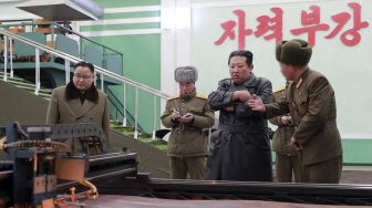 Pemimpin Korea Utara Kim Jong Un (kedua kanan) memeriksa pabrik amunisi yang memproduksi sistem senjata utama di lokasi yang dirahasiakan, dirilis oleh Kantor Berita Pusat Korea (KCNA) Resmi Korea Utara pada (28/1/2022). [STR / AFP / KCNA VIA KNS]
