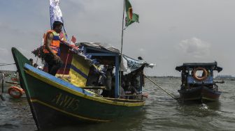 Sejumlah nelayan dan warga menggunakan kapal menuju lokasi melarung (menghanyutkan) sesaji di laut Tarumajaya, Kabupaten Bekasi, Jawa Barat, Jumat (28/1/2022). [ANTARA FOTO/Fakhri Hermansyah]
