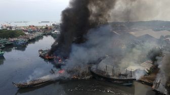 Foto udara suasana kapal nelayan terbakar di Pelabuhan Tegal, Jawa Tengah, Sabtu (29/1/2022). [ANTARA FOTO/Oky Lukmansyah]