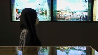 Pengunjung melihat karya seni yang ditampilkan dalam pameran 'Para Sekutu yang Tidak Bisa Berkata Tidak' di Galeri Nasional Indonesia, Jakarta Pusat, Minggu (30/1/2022). [Suara.com/Alfian Winanto]