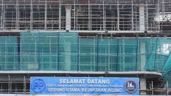 Pekerja beraktivitas di proyek pembangunan gedung Kejaksaan Agung Republik Indonesia di Jakarta Selatan, Selasa (1/2/2022). [Suara.com/Alfian Winanto]