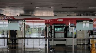  Seorang penumpang berjalan meninggalkan gerbong kereta LRT yang berhenti di Stasiun LRT Velodrome, Pulo Gadung, Jakarta, Selasa (1/2/2022). [Suara.com/Angga Budhiyanto]