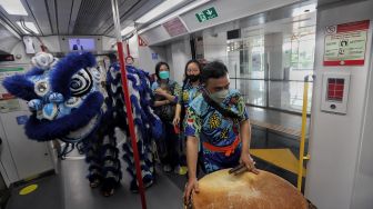 Barongsai berjalan di dalam gerbong LRT, Jakarta, Selasa (1/2/2022). [Suara.com/Angga Budhiyanto]