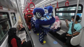 Barongsai menghibur penumpang di dalam gerbong LRT, Jakarta, Selasa (1/2/2022). [Suara.com/Angga Budhiyanto]