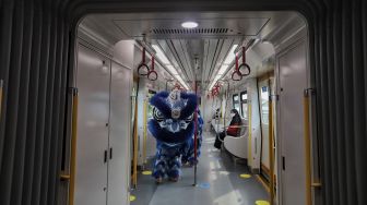 Barongsai menghibur penumpang di dalam gerbong LRT, Jakarta, Selasa (1/2/2022). [Suara.com/Angga Budhiyanto]