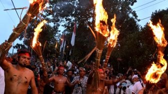 Sejumlah warga saling memukulkan api dari daun kelapa kering saat mengikuti tradisi "Siat Api" atau perang api di Desa Adat Duda, Karangasem, Bali, Senin (31/1/2022).  ANTARA FOTO/Fikri Yusuf