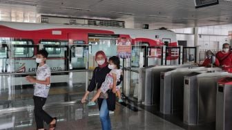 Sejumlah penumpang berjalan meninggalkan gerbong kereta LRT yang berhenti di Stasiun LRT Velodrome, Pulo Gadung, Jakarta, Selasa (1/2/2022). [Suara.com/Angga Budhiyanto]