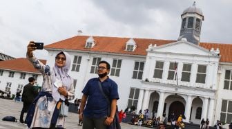 Warga berswafoto saat berwisata di Kawasan Kota Tua, Jakarta Barat, Selasa (1/2/2022). [Suara.com/Alfian Winanto]