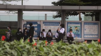 Sejumlah pekerja menunggu bus di kawasan Sudirman, Jakarta, Rabu (2/2/2022). [Suara.com/Angga Budhiyanto]