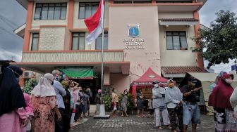 Warga mengantre untuk membeli sembako murah di Kantor Kelurahan Cililitan, Jakarta, Rabu (2/2/2022). [Suara.com/Angga Budhiyanto]