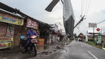 Warga berada di dekat tiang listrik yang roboh di Banguntapan, Bantul, DI Yogyakarta, Rabu (2/2/2022). ANTARA FOTO/Hendra Nurdiyansyah