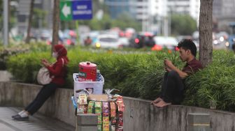 Pedagang duduk di area trotoar kawasan Sudirman, Jakarta, Rabu (2/2/2022). [Suara.com/Angga Budhiyanto]