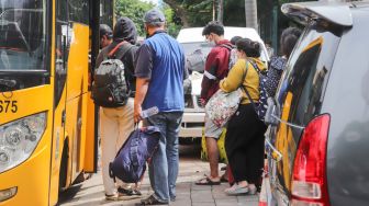 Para pasien Covid-19 saat dievakuasi ke RSDC Wisma Atlet di Puskesmas Kecamatan Tebet, Jakarta Selatan, Kamis (3/2/2022). [Suara.com/Alfian Winanto]