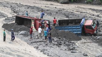 Warga membantu proses evakuasi truk yang terjebak banjir lahar di aliran Sungai Boyong, Sleman, DI Yogyakarta, Kamis (3/2/2022).  ANTARA FOTO/Hendra Nurdiyansyah