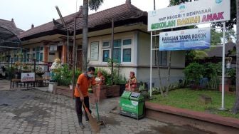 Petugas membersihkan area sekolah di SMP Negeri 1 Denpasar, Bali, Jumat (4/2/2022). ANTARA FOTO/Nyoman Hendra Wibowo
