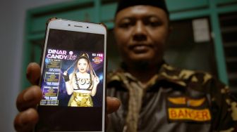 Ketua Satuan Koordinasi Cabang (Kasatkorcab) Barisan Ansor Serbaguna (BANSER) Kota Blitar Syarifuddin Ahmad, menunjukkan poster digital berisi promosi penampilan DJ Dinar Candy di Sekretariat GP ANSOR Kota Blitar, Jawa Timur, Kamis (3/1/2022). ANTARA FOTO/Irfan Anshori