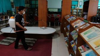 Petugas menyemprotkan disinfektan pada area perpustakaan di SMP Negeri 1 Denpasar, Bali, Jumat (4/2/2022). ANTARA FOTO/Nyoman Hendra Wibowo