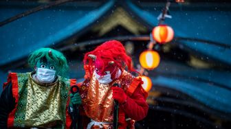 Penampil yang mengenakan topeng monster dan kostum 'oni' berkumpul untuk tradisi 'Mamemaki' saat perayaan Setsubun di Kuil Fukushima Inari, Jepang, (3/2/2022). [Photo by Philip FONG / AFP]