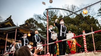 Warga berkumpul untuk tradisi 'Mamemaki' saat perayaan Setsubun di Kuil Fukushima Inari, Jepang, (3/2/2022). [Photo by Philip FONG / AFP]