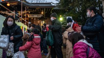 Warga berkumpul untuk tradisi 'Mamemaki' saat perayaan Setsubun di Kuil Fukushima Inari, Jepang, (3/2/2022). [Photo by Philip FONG / AFP]