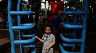 Seorang anak bermain di Taman Lapangan Banteng, Jakarta, Minggu (6/2/2022). [Suara.com/Angga Budhiyanto]