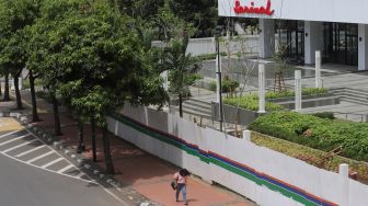 Pejalan kaki melintas di depan Gedung Sarinah, Jakarta, Minggu (6/2/2022). [Suara.com/Angga Budhiyanto] 