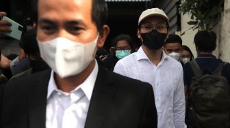 Selebgram sekaligus Youtuber Indra Kesuma atau Indra Kenz (keempat kanan) berjalan usai memberikan laporan di Gedung SPKT Polda Metro Jaya, Jakarta, Senin (7/2/2022). [Suara.com/Angga Budhiyanto]