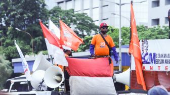 Sejumlah massa buruh melaksanakan aksi di depan Gedung DPR, Jakarta Pusat, Senin (7/2/2022). [Suara.com/Alfian Winanto]