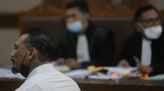 Terdakwa yang juga musisi I Gede Ari Astina atau Jerinx Superman is Dead (SID) menjalani sidang lanjutan kasus pengancaman melalui media elektronik pada Adam Deni dengan agenda mendengarkan keterangan dari saksi ahli di Pengadilan Negeri (PN) Jakarta Pusat, Jakarta, Senin (7/2/2022). [Suara.com/Angga Budhiyanto]