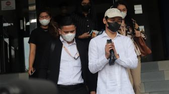 Selebgram sekaligus Youtuber Indra Kesuma atau Indra Kenz (kedua kanan) menyapa awak media usai memberikan laporan di Gedung SPKT Polda Metro Jaya, Jakarta, Senin (7/2/2022). [Suara.com/Angga Budhiyanto]