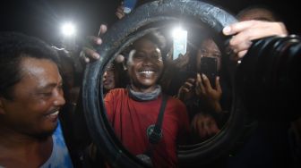 Penakluk buaya terjerat ban bekas sepeda motor, Tili menunjukkan ban yang berhasil dilepaskan dari leher buaya di Sungai Palu, Palu, Sulawesi Tengah, Senin (7/2/2022). ANTARA FOTO/Basri Marzuki