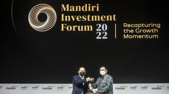 Wamen BUMN II Kartika Wirjoatmodjo (kiri) menerima cendera mata dari Direktur Utama Bank Mandiri Darmawan Junaidi (kanan) pada Mandiri Investment Forum 2022 di Jakarta, Rabu (9/2/2022). ANTARA FOTO/Muhammad Adimaja