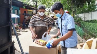 Warga membeli bahan pangan murah dalam kegiatan Program Pangan Bersubsidi di RPTRA Kebon Melati, Jakarta Pusat, Rabu (9/2/2022). [Suara.com/Alfian Winanto]