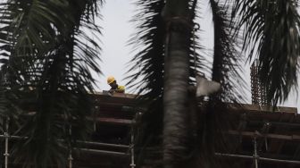 Pekerja menyelesaikan proyek salah satu gedung bertingkat di Jakarta, Kamis (10/2/2022). [Suara.com/Angga Budhiyanto]