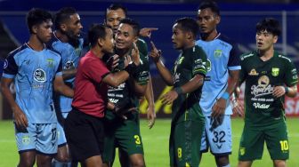 Pesepak bola Persebaya Surabaya melakukan protes kepada wasit Nendi Rohaendi (tengah) usai gol ke gawang Persela Lamongan dianulir pada pertandingan Liga 1 di Stadion I Gusti Ngurah Rai, Denpasar, Bali, Kamis (10/2/2022) malam. ANTARA FOTO/Nyoman Hendra Wibowo.