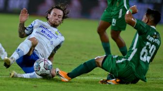 Pesepak bola Persib Bandung Marc Klok (kiri) berebut bola dengan pesepak bola PSS Sleman Derry Rachman Noor (kanan) saat pertandingan Liga 1 di Stadion Kapten I Wayan Dipta, Gianyar, Bali, Jumat (11/2/2022). [ANTARA FOTO/Fikri Yusuf]