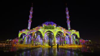 Masjid Sharjah menyala dalam tampilan warna-warni saat Festival Cahaya Sharjah ke-11 di Uni Emirat Arab, Kamis (10/2/2022). [Giuseppe CACACE / AFP]