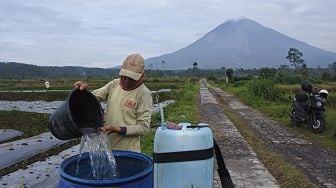 
Petani mencampur pupuk untuk tanaman cabai merah dengan latar belakang Gunung Semeru di Desa Supiturang, Pronojiwo, Lumajang, Jawa Timur, Sabtu (12/2/2022). [ANTARA FOTO/Seno/pras]