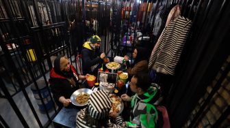 Pengunjung makan malam di restoran "Cell 16' yang berkonsep penjara di Teheran, Iran, Jumat (4/2/2022). [ATTA KENARE / AFP]