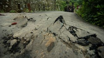 Kondisi jalan desa yang retak akibat bencana tanah bergerak di Desa Dermasuci, Kabupaten Tegal, Jawa Tengah, Minggu (13/2/2022). ANTARA FOTO/Oky Lukmansyah