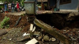 Warga memperhatikan lantai rumah yang amblas akibat bencana tanah bergerak di Desa Dermasuci, Kabupaten Tegal, Jawa Tengah, Minggu (13/2/2022). ANTARA FOTO/Oky Lukmansyah

