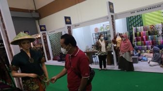 Pengunjung melihat koleksi kain tradisional saat Pameran Adiwastra Nusantara di Jakarta Convention Center (JCC), Jakarta, Minggu (13/2/2022). [Suara.com/Angga Budhiyanto]