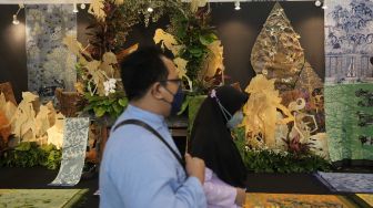 Pengunjung melihat koleksi kain tradisional saat Pameran Adiwastra Nusantara di Jakarta Convention Center (JCC), Jakarta, Minggu (13/2/2022). [Suara.com/Angga Budhiyanto]