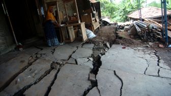 Seorang warga menunjukkan lantai rumah yang rusak parah akibat bencana tanah bergerak di Desa Dermasuci, Kabupaten Tegal, Jawa Tengah, Senin (14/2/2022).  ANTARA FOTO/Oky Lukmansyah